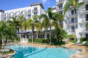 a swimming pool in front of a building with palm trees at Inn at Pelican Bay in Naples