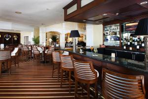 a bar with wooden chairs and a lot of bottles of wine at Inn at Pelican Bay in Naples