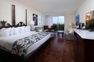 a bedroom with a bed and a bathroom with a sink at Inn at Pelican Bay in Naples
