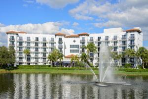 a fountain in the middle of a pond in front of a building at Inn at Pelican Bay in Naples