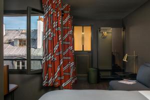 a room with a bed and a window with a view at Hôtel Louvre Piemont & Spa in Paris