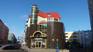 ein Gebäude mit rotem Dach auf einer Stadtstraße in der Unterkunft TOP Apartments 2 in Stettin