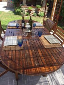 - une table en bois avec des bouteilles de vin et des verres dans l'établissement Rustico del Chiasso, à Capannori