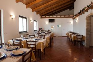 una grande sala con tavoli e sedie in un ristorante di La Camilla Country House a Graffignano