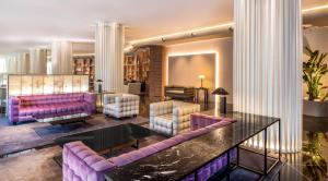 uma sala de estar com sofás roxos e uma mesa em SH Valencia Palace em Valência