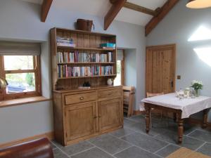 a dining room with a book shelf and a table at Danygraig Cottage in Carmarthen
