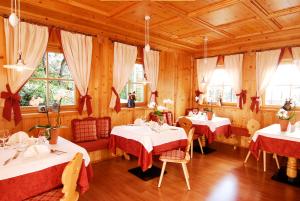un ristorante con due tavoli con tovaglia rossa e bianca di Hotel Ortler a Tirolo