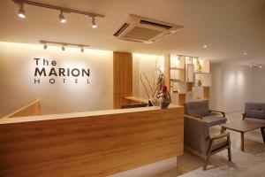 a hotel lobby with a reception desk and chairs at The Marion Hotel in Johor Bahru
