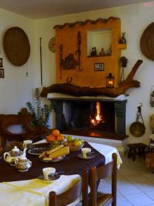 Villagrande StrisailiにあるFattoria Nuraghe Murtarbaのリビングルーム(テーブル、暖炉付)