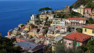 eine Gruppe von Häusern auf einem Hügel neben dem Meer in der Unterkunft AWroom in Riomaggiore