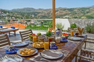 a wooden table with plates of food on it at Casa Sofia in Spílion