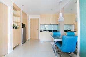 a kitchen with a table and blue chairs at Caribbean Hotel Resort Pattaya in Pattaya South