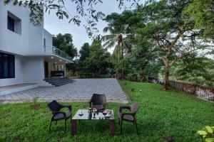 a table and chairs in the yard of a house at Nadhiyoram River Retreat in Cochin