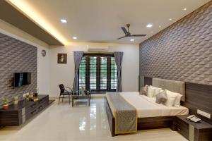 a bedroom with a bed and a desk and a television at Nadhiyoram River Retreat in Cochin