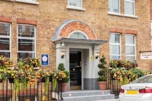 un edificio de ladrillo con flores delante de una puerta en Blandford Hotel, en Londres