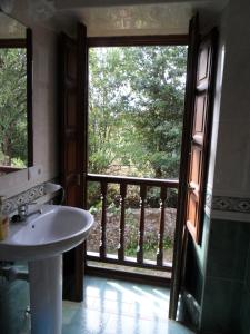 a bathroom with a sink and a large window at Hotel Rural Cuadroveña in Arriondas