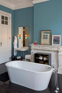 bañera blanca en una habitación con chimenea en Appartement Chic, en Bruselas