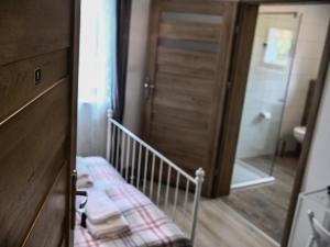 a bathroom with a wooden door and a stairway with a towel at Harmony Hostel in Zator