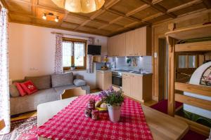 Eine Küche und ein Wohnzimmer mit einem Tisch mit roter Tischdecke in der Unterkunft Haus Ploner - Pichlerhof in Kiens