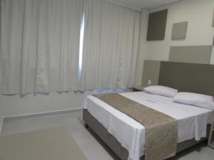 Tempat tidur dalam kamar di Hotel Urbis a 10 minutos Rua 25 de Março, Brás,Bom Retiro,a 2 minutos do Mirante Sampa Sky e pista de Skate Anhangabaú