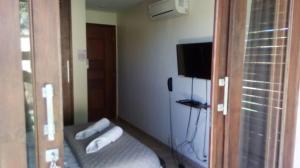 a room with a bed and a flat screen tv at Suite Pipa Beleza Spa Resort in Pipa