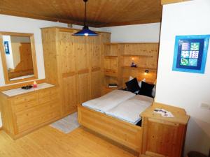 ein Schlafzimmer mit einem Bett in einem Zimmer mit Holzwänden in der Unterkunft Ciasa Confolia in Kurfar