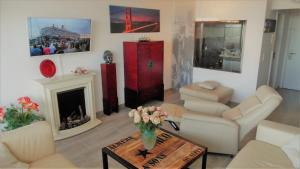 a living room with white furniture and a fireplace at Luxussuite 1A Meerblick, Maritim Residenz, 22er Stock, modernes Styling, am Strand in Travemünde
