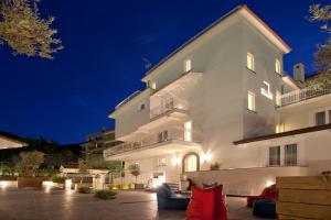 a large white building with a couch in front of it at Maison Kalea in Sorrento