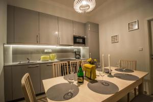 プラハにある3BDR City Center Ruterra Apartmentのキッチン(ワイングラス付きのテーブル付)