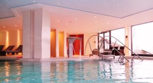 a swimming pool with a water slide in a building at Luxussuite 1A Meerblick, Maritim Residenz, 22er Stock, modernes Styling, am Strand in Travemünde