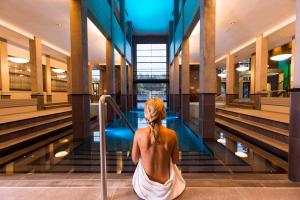 een vrouw die op de trap zit in een gebouw bij Hotel & Wellness Zuiver in Amsterdam