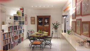 a dining room with a table and bookshelves at B&B Villa Ada in Formia
