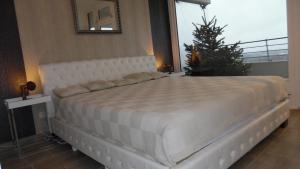 a large white bed in a bedroom with a christmas tree at Luxussuite 1A Meerblick, Maritim Residenz, 22er Stock, modernes Styling, am Strand in Travemünde +65 photos
