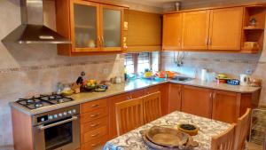 eine Küche mit Holzschränken und einem Herd mit Backofen in der Unterkunft Casa da Quinta in Oliveira do Hospital + 20 Fotos