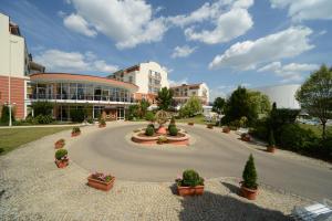 a building with a circular driveway with potted plants at The Monarch Hotel in Bad Gögging