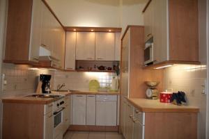 a small kitchen with white cabinets and wooden counters at 70m² großes Apartment mit Gartenzugang in Vienna