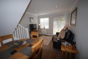 a living room with a table and a couch at The Beeches Holiday Cottage in Auchterarder