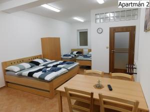 Habitación con 3 camas, mesa y sillas en Apartmány Horní Planá en Horní Planá