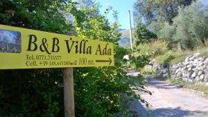 een geel bord voor een weg in een dorp bij B&B Villa Ada in Formia