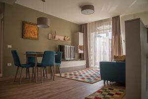 a living room with a table and blue chairs at Apartment Cristian 2 in Timişoara