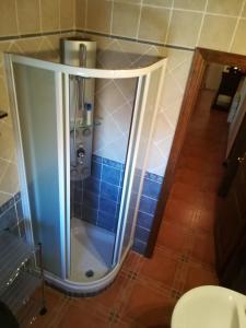 y baño con ducha y azulejos azules. en Casa Rural La Muralla, en Retortillo de Soria