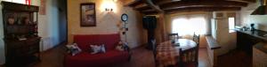 due gatti seduti su due divani rossi in una stanza di Casa Rural La Muralla a Retortillo de Soria