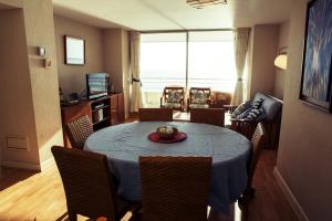 una mesa de comedor con un paño de mesa azul y sillas en San Alfonso del Mar - Algarrobo 886, en Algarrobo