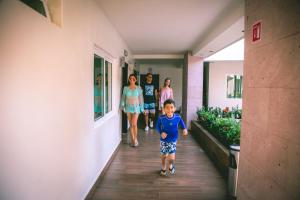 un grupo de personas caminando por un pasillo con un niño en Luxury Hotel Inn en Peñita de Jaltemba