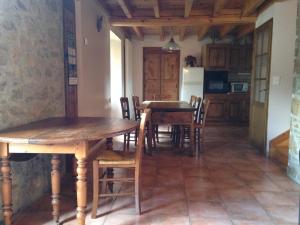 a kitchen with wooden tables and chairs in a room at Maison de caractère en Pierre Cal Blanic in Saint-Pierre-dels-Forcats