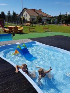 two children are swimming in a swimming pool at U Sasiadow in Mielenko