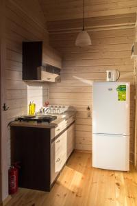 a kitchen with a white refrigerator and wooden walls at U Sasiadow in Mielenko