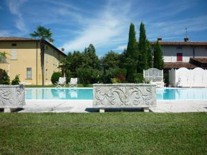 dwie kamienne ławki przed basenem w obiekcie Cascina Maria w mieście Desenzano del Garda