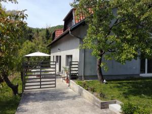 a white building with a tree and a sidewalk at Apartments Garden Zagreb in Zagreb