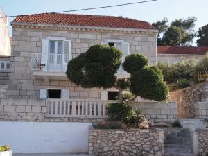 a house with a white fence in front of it at Apartments Lumbarda Beach in Lumbarda